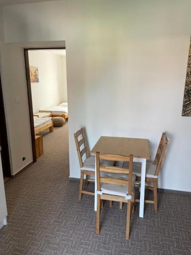 a table and chairs in a room with a bedroom at Apartmány u Pálavy in Přítluky
