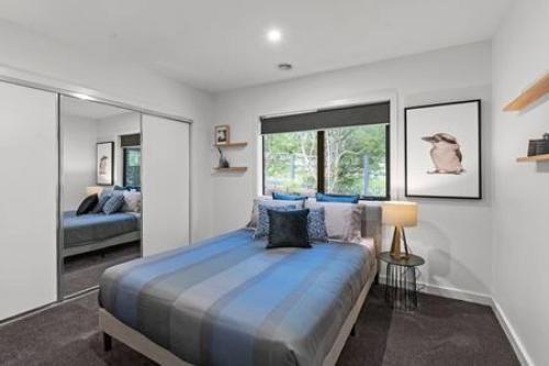 a bedroom with a large bed and a large window at BADGER HOUSE - 4 Bed, 4 Bath, Stunning Entertainer plus Fire in Healesville