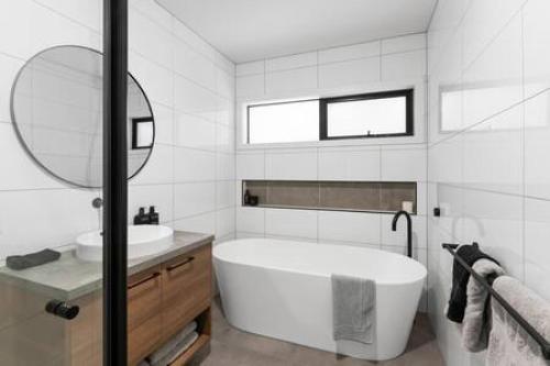 a bathroom with a tub and a sink and a mirror at BADGER HOUSE - 4 Bed, 4 Bath, Stunning Entertainer plus Fire in Healesville