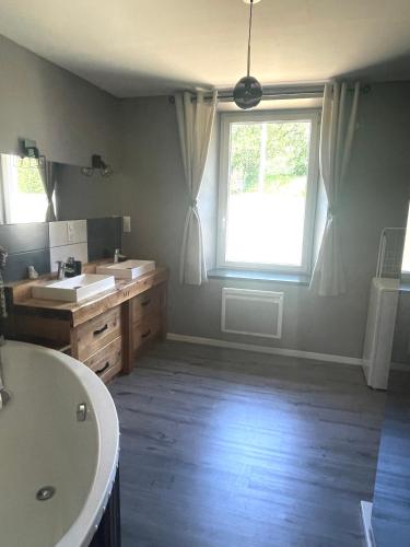 La salle de bains est pourvue de 2 lavabos et d'une grande fenêtre. dans l'établissement Gîte de la Belette_Montagne de La Bresse, à Cornimont