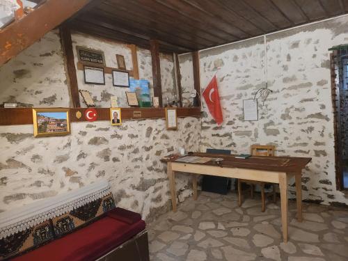 a room with a wooden table in a stone wall at Fatma Hanım Konağı butik Otel in Safranbolu