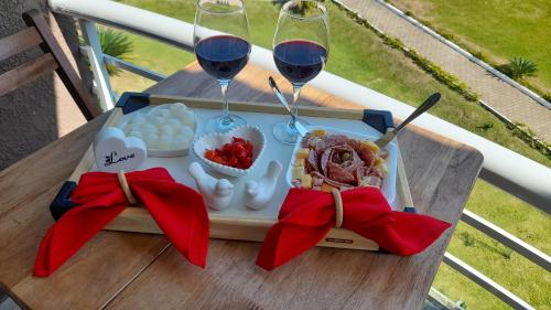 a tray of food and two glasses of wine on a table at Aldeia das Aguas Village in Barra do Piraí