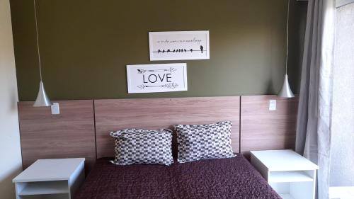 sypialnia z łóżkiem z zagłówkiem i 2 poduszkami w obiekcie Aldeia das Aguas Village w mieście Barra do Piraí