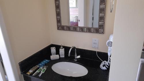 a bathroom with a black sink and a mirror at Aldeia das Aguas Village in Barra do Piraí