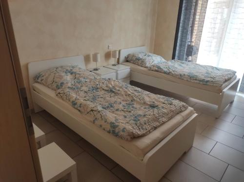 2 Betten in einem Zimmer mit Fenster in der Unterkunft FeWo Holunderbusch in Saerbeck