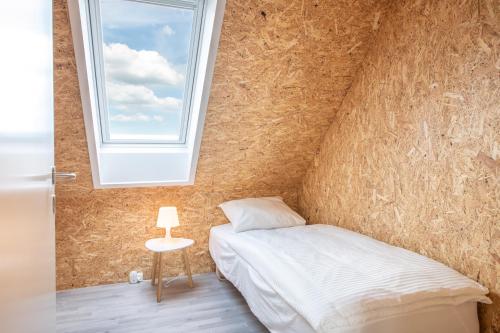 a bedroom with a bed and a window at Fuglhus - hyggelig ferie på landet in Rødekro