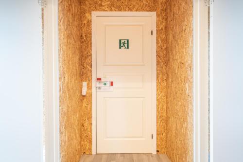 a white door with a sign on it in a room at Fuglhus - hyggelig ferie på landet in Rødekro