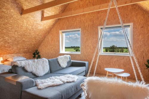 a living room with a couch and a swing at Fuglhus - hyggelig ferie på landet in Rødekro