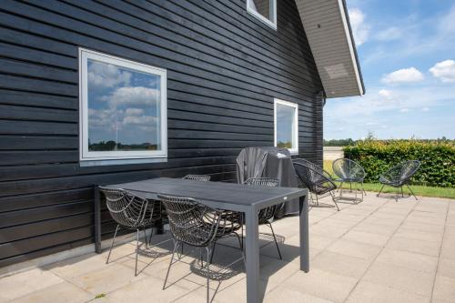 einen Tisch und Stühle auf einer Terrasse in der Unterkunft Fuglhus - hyggelig ferie på landet in Rødekro