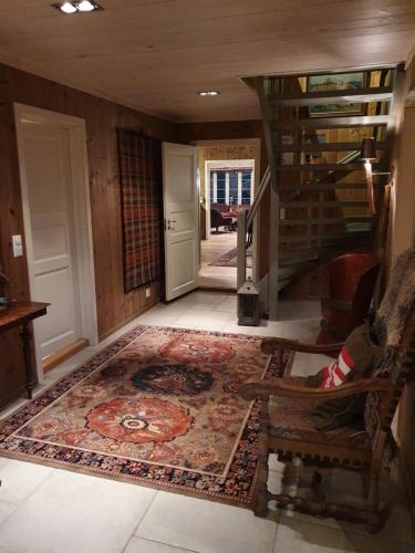 a living room with a staircase and a rug at Luxurious, well-Equipped and modern Cabin by the Cross-Country Ski Trails in Eggedal