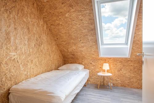 a bedroom with a bed and a window at Fuglhus - hyggelig ferie på landet in Rødekro