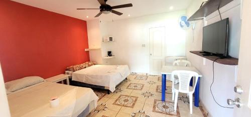 Zimmer mit 2 Betten und einem Flachbild-TV in der Unterkunft Villa Trinidad in La Ceiba