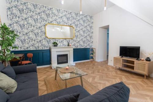 a living room with a couch and a fireplace at Modern Guest -Sainte Eulalie in Sainte-Eulalie
