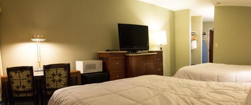 a hotel room with a bed and a flat screen tv at Aderi Hotel Near Casino in Niantic