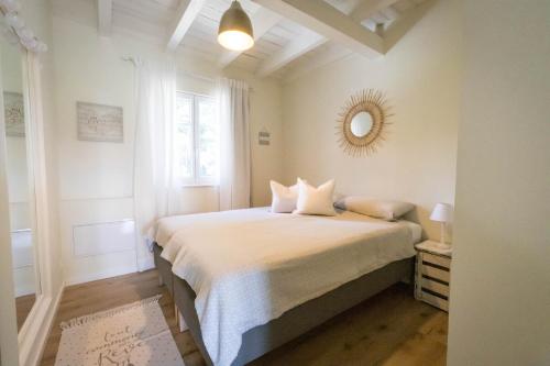 um quarto branco com uma cama e um espelho em Romantik-Home Nordelsass - Ferienwohnung für Selbstversorger em Oberhoffen-lès-Wissembourg