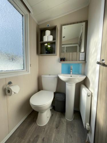 a small bathroom with a toilet and a sink at Sea Breeze in Perranporth