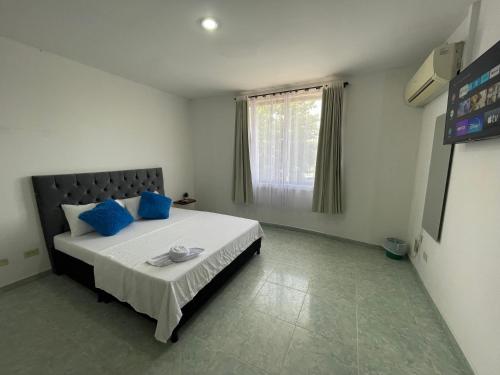 ein Schlafzimmer mit einem großen Bett mit blauen Kissen in der Unterkunft Alojamiento Yopal in Yopal