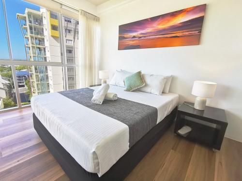 um quarto com uma cama grande e uma janela grande em Oxygen Apartments em Brisbane