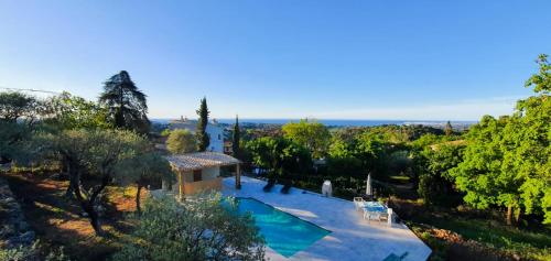 - une vue extérieure sur une villa avec une piscine et des arbres dans l'établissement Paisible et Spacieuse Villa avec 4 suites indépendantes, à La Gaude