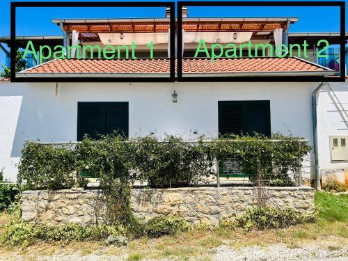 a building with a stone wall in front of it at Apartmani Zora in Kruševo