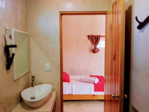 a bathroom with a sink and a toilet and a bed at Tribe Beachville in El Cuyo