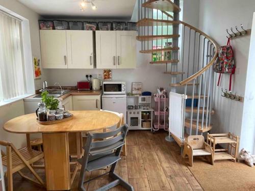 uma cozinha com uma mesa de madeira e uma escada em espiral em Family Break in Newmarket em Newmarket