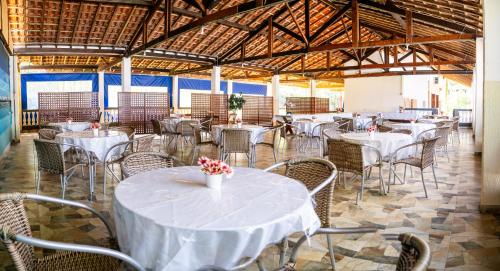a dining room with white tables and chairs at Pousada Bem Viver in Ubatuba