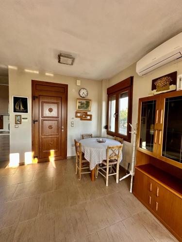 a dining room with a table and chairs and a clock at Villa Elia in Nea Kallikrateia in Nea Kalikratia