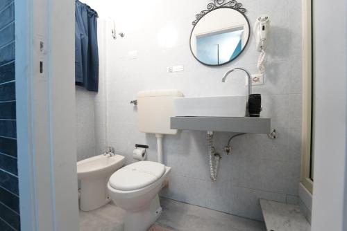 a bathroom with a toilet and a sink and a mirror at Airport suite in Catania