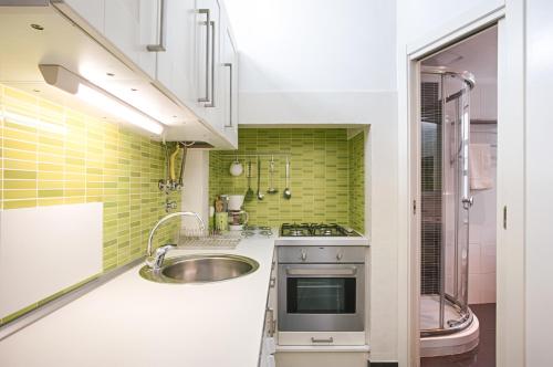 a small kitchen with a sink and green tiles at BmyGuest - Príncipe Real Galeria Apartment in Lisbon