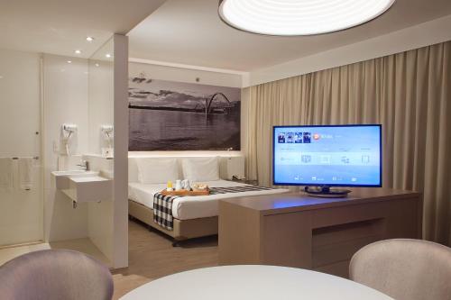 a hotel room with a bed and a computer on a desk at ibis Styles Brasilia Aeroporto in Brasilia