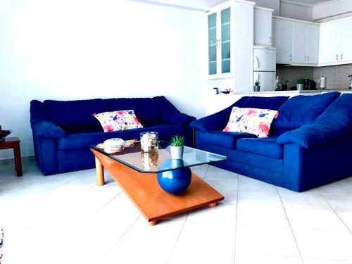 sala de estar con sofá azul y mesa en ΑquaView, en Gythio