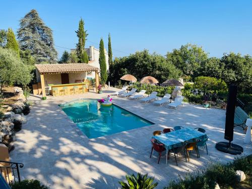 - une piscine avec une table et des chaises dans la cour dans l'établissement Paisible et Spacieuse Villa avec 4 suites indépendantes, à La Gaude