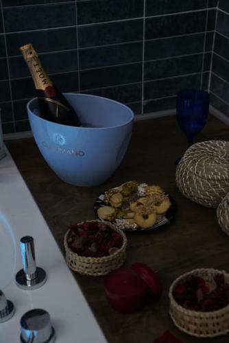 a bottle of champagne in a bowl next to some food at Airport suite in Catania