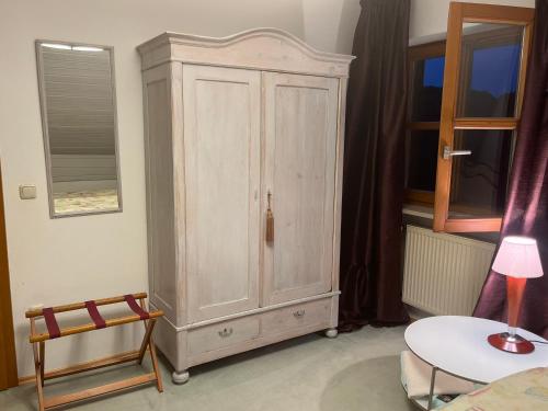 a large wooden cabinet in a room with a table at Zimmer zum Wohlfühlen in Eching
