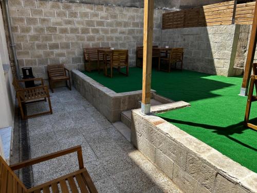 a patio with a green floor and tables and chairs at Bohobos Hostel in Antibes
