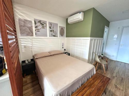 a small bedroom with a bed and a chair at STUDIO COMPLETO - CENTRO - Com GARAGEM in Juiz de Fora