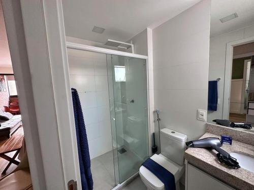 a bathroom with a toilet and a glass shower at STUDIO COMPLETO - CENTRO - Com GARAGEM in Juiz de Fora