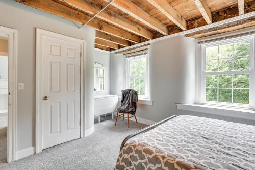 1 dormitorio con cama, bañera y ventanas en Spacious Country Home in Coatesville on Old Ranch!, en Coatesville