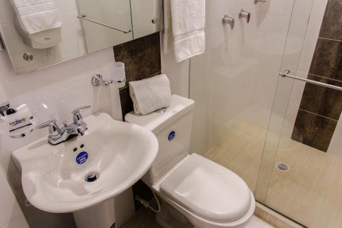 y baño con lavabo, aseo y ducha. en Hotel la Ciudad, en Barrancabermeja
