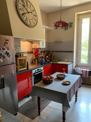 a kitchen with a table and a clock on the wall at Vue cité de Carcassonne in Carcassonne