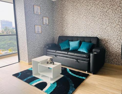 a living room with a black couch and a white table at La mejor experiencia: ubicación y comodidad in Ibagué