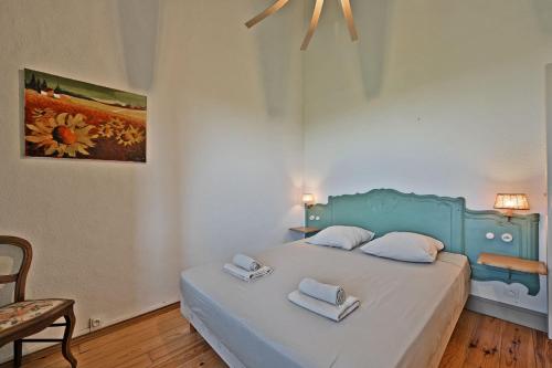 a bedroom with a blue bed with two towels on it at Le CAMPAGNE in Beaucaire