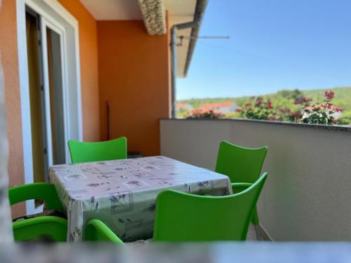 una mesa y sillas verdes en una habitación con ventana en Apartments ADELA, en Polje