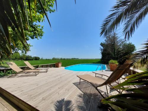 a wooden deck with chairs and a swimming pool at Le CAMPAGNE in Beaucaire