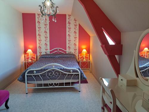a bedroom with a bed with red walls and a mirror at Chambres d'hôtes le haut de la lande in Crollon