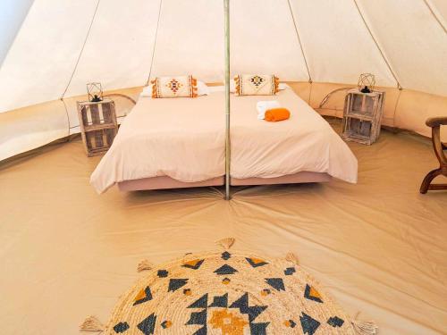 1 dormitorio en una tienda de campaña con 1 cama y 1 alfombra en Parque da Mina en Monchique