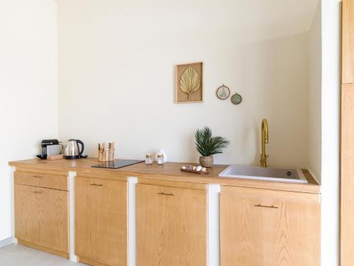 uma cozinha com armários de madeira e um lavatório em Kartika Charming House em Lampedusa