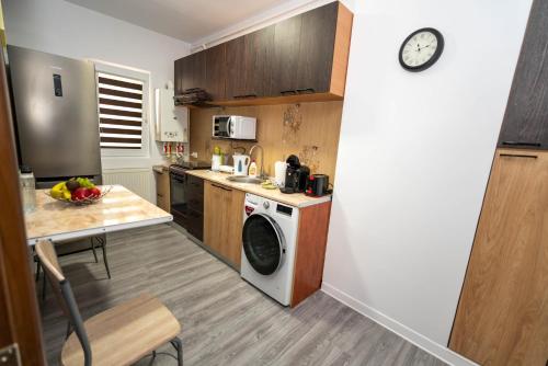 a kitchen with a washing machine and a table and a clock at Hotel Studio Titan in Bucharest
