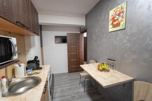 a kitchen with a sink and a table with fruit on it at Hotel Studio Titan in Bucharest